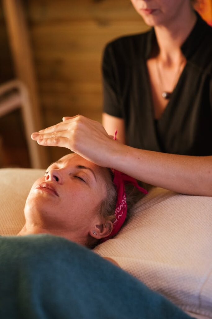 The Entrepreneur’s Guide to Turning Ideas Into Profitable Relaxed woman with closed eyes lying under blanket while getting reiki therapy treatment from unrecognizable therapist in cozy salon with blurred background