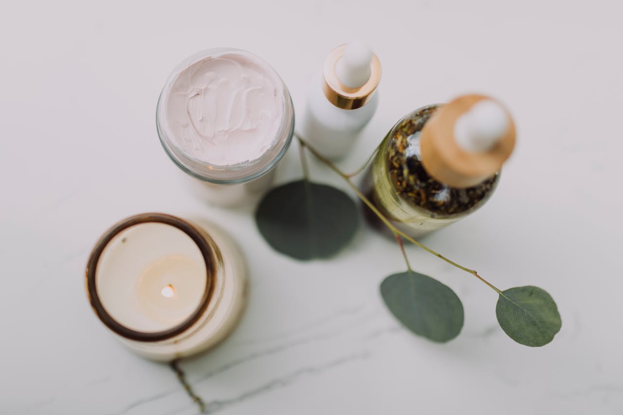 our-journey-02 Calming spa scene featuring skincare items, a candle, and eucalyptus leaves for relaxation.